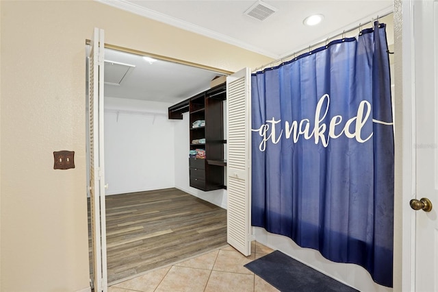 bathroom with a shower with curtain, visible vents, crown molding, and tile patterned floors