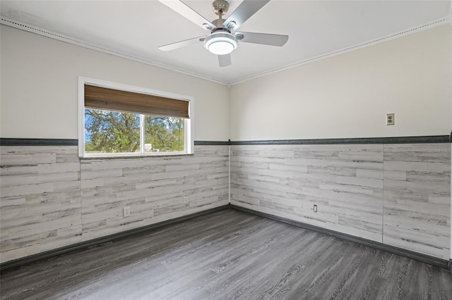 spare room featuring ceiling fan, ornamental molding, wood finished floors, and wainscoting