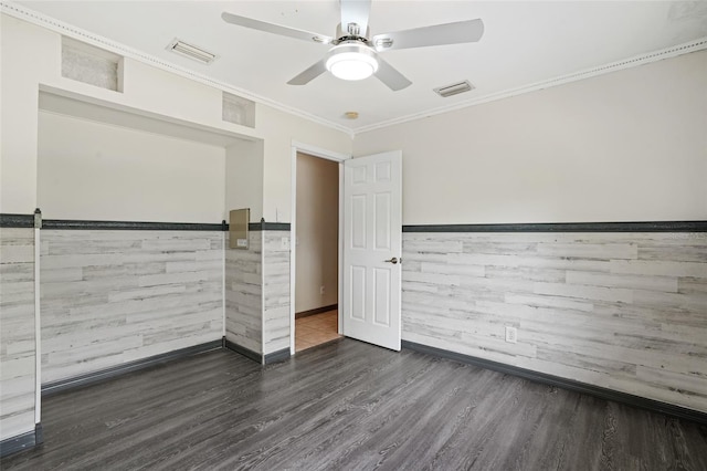 unfurnished room featuring ornamental molding, wood finished floors, visible vents, and a ceiling fan