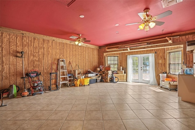 misc room with french doors, tile patterned floors, visible vents, and wooden walls