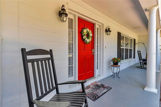 doorway to property with a porch and concrete block siding