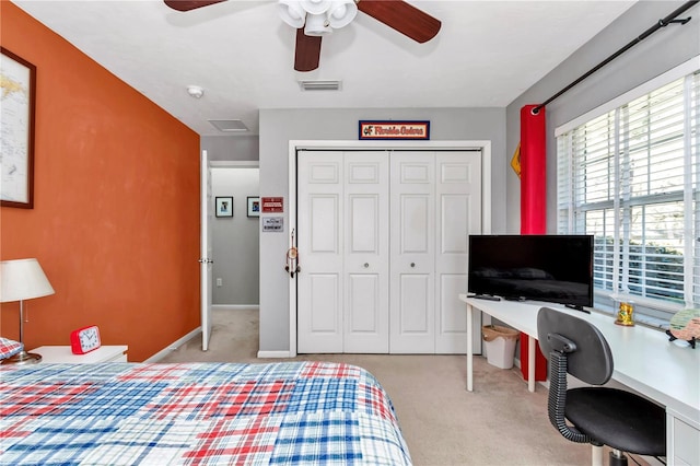 carpeted bedroom with a closet, visible vents, baseboards, and a ceiling fan