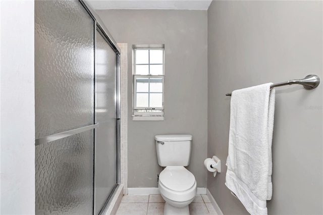 full bathroom featuring tile patterned flooring, a shower stall, toilet, and baseboards