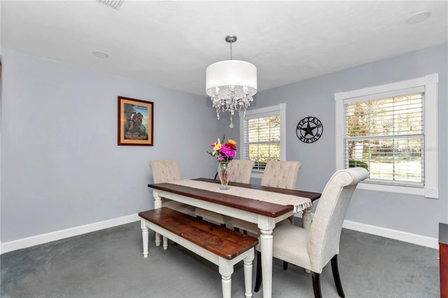 dining area with baseboards, plenty of natural light, and a notable chandelier