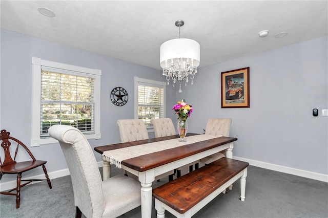 carpeted dining area featuring baseboards and a notable chandelier