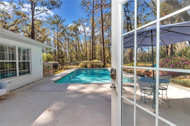 pool with glass enclosure and a patio