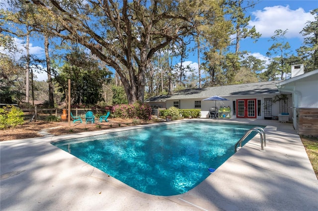 outdoor pool featuring french doors and a patio