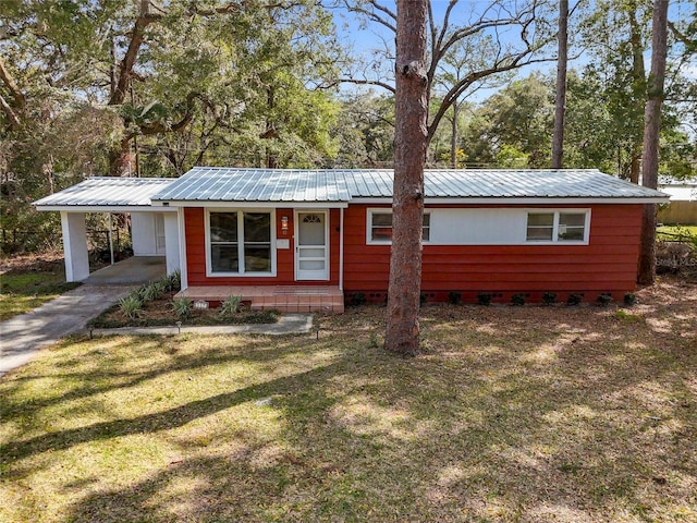 view of front of home featuring an attached carport, a front lawn, driveway, and metal roof