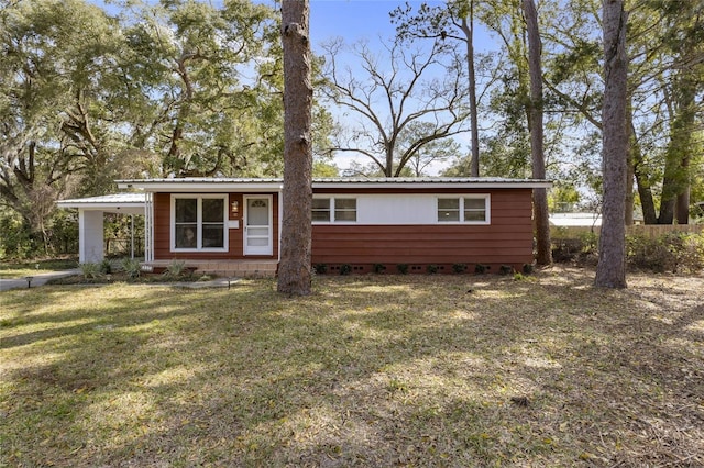 view of front of property featuring metal roof and a front yard