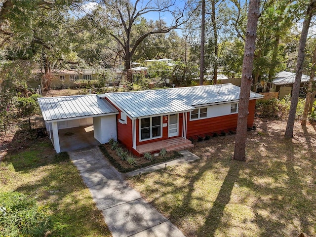 ranch-style house with a front yard, driveway, and metal roof