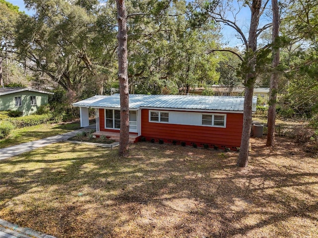 view of front of home with metal roof and a front yard