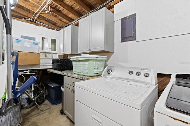 washroom featuring electric panel, cabinet space, and washing machine and clothes dryer