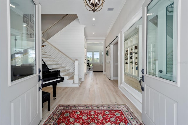 entrance foyer featuring visible vents, ornamental molding, light wood-style flooring, recessed lighting, and a chandelier