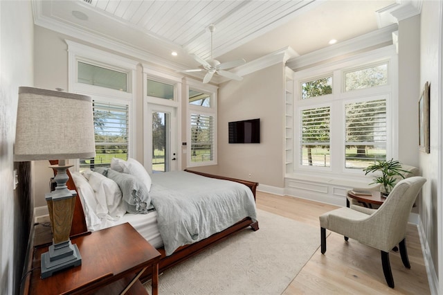 bedroom featuring light wood finished floors, ceiling fan, crown molding, and baseboards