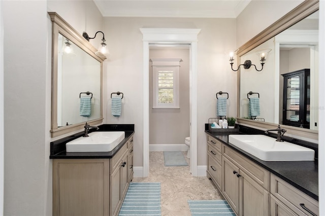 bathroom featuring a sink, baseboards, and two vanities