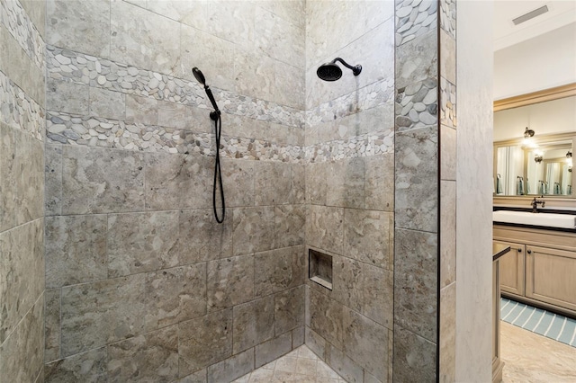 full bathroom featuring tiled shower, vanity, and crown molding