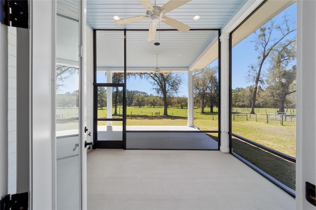 unfurnished sunroom featuring ceiling fan