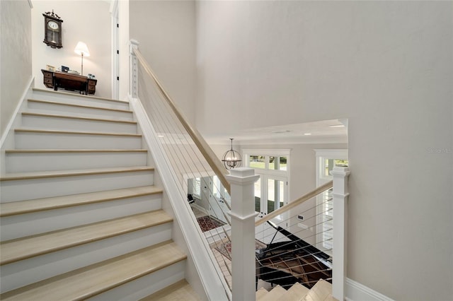 stairs featuring baseboards and a chandelier