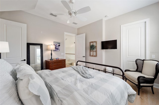 bedroom featuring visible vents, lofted ceiling, light wood-style floors, and ceiling fan