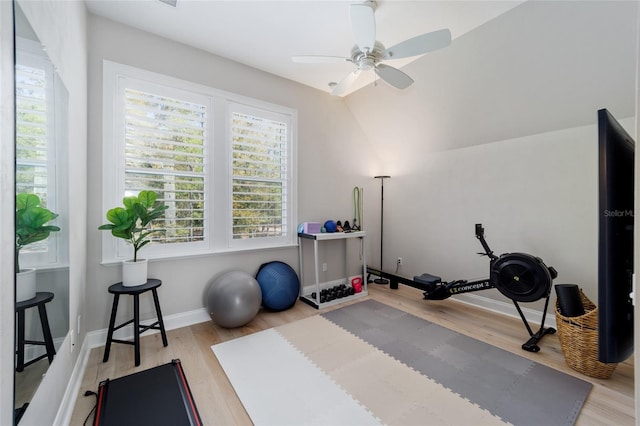 exercise room with baseboards, wood finished floors, and a ceiling fan