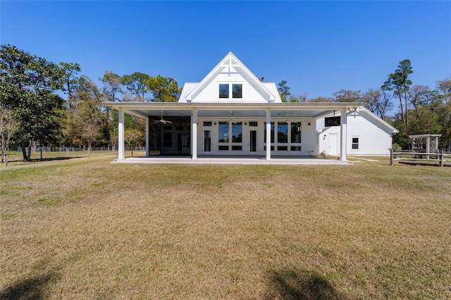 rear view of property with a yard, a ceiling fan, and a patio area