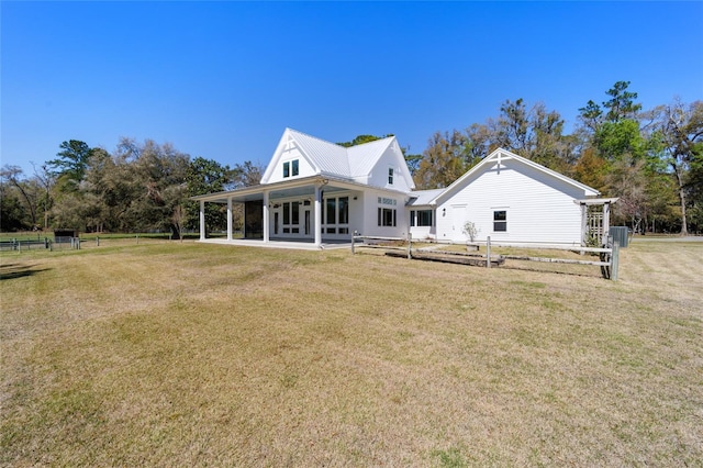 rear view of property featuring a patio, a lawn, and fence