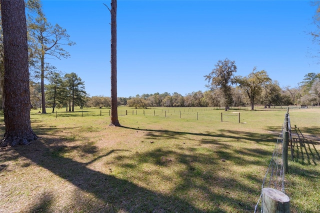 view of yard featuring a rural view and fence