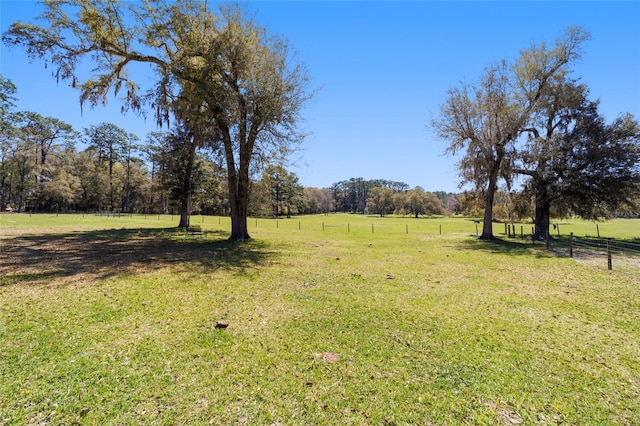 view of yard featuring a rural view and fence