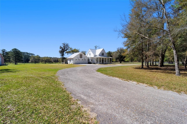 view of front of house with curved driveway and a front lawn