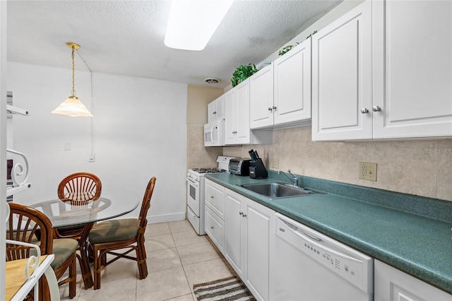 kitchen featuring decorative light fixtures, light tile patterned flooring, white cabinets, white appliances, and a sink