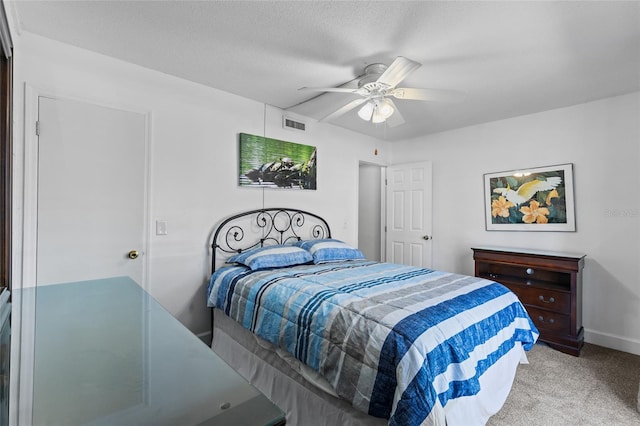 carpeted bedroom featuring baseboards, visible vents, a textured ceiling, and ceiling fan