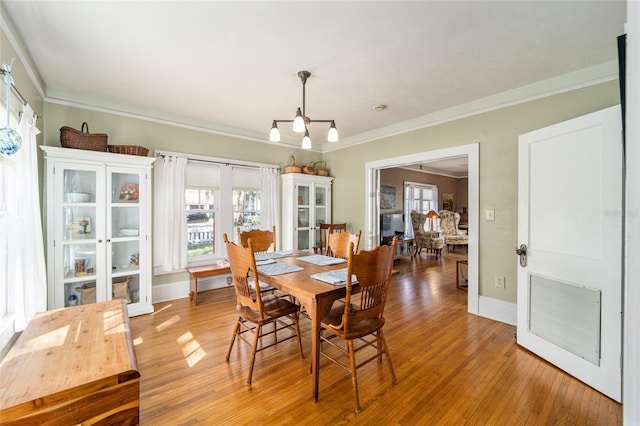 dining space with visible vents, plenty of natural light, crown molding, and light wood finished floors