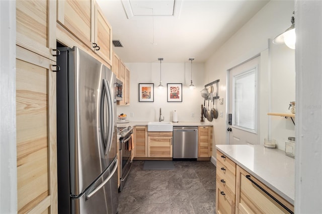 kitchen featuring light brown cabinetry, appliances with stainless steel finishes, light countertops, and a sink