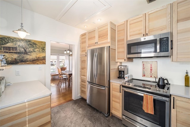 kitchen with pendant lighting, appliances with stainless steel finishes, light brown cabinets, and light countertops