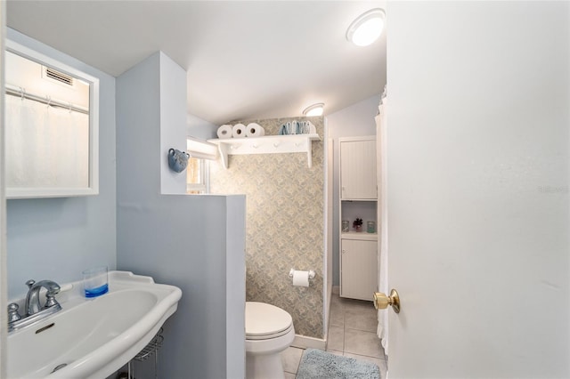 bathroom featuring tile patterned floors, toilet, visible vents, and a sink