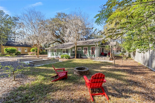 view of yard with a garden, fence, and an outdoor fire pit