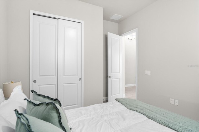 bedroom with a closet, baseboards, and visible vents