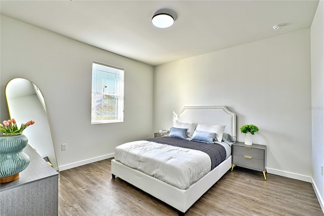 bedroom with baseboards and wood finished floors