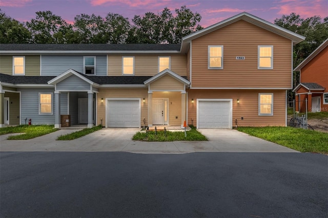 townhome / multi-family property with concrete driveway, an attached garage, and a shingled roof