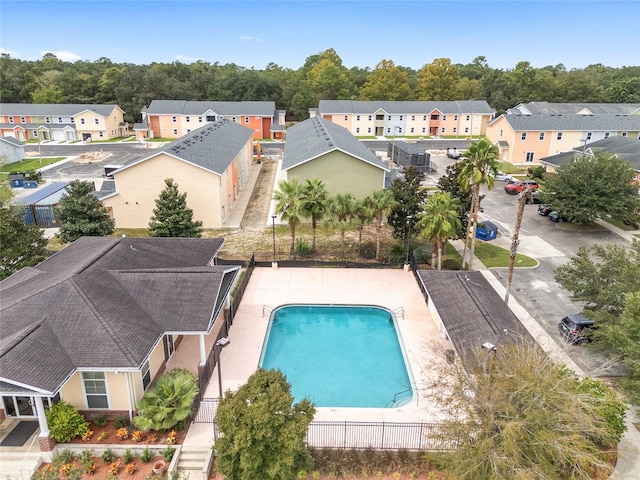 view of swimming pool with a fenced in pool, a residential view, and fence