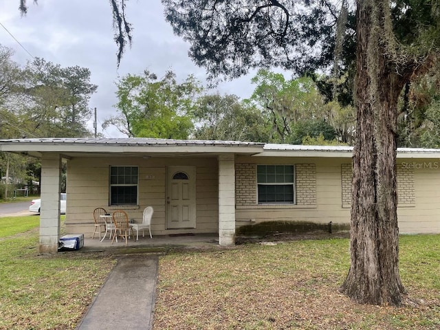 view of front of home with metal roof and a front yard