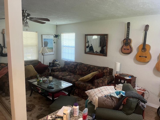 living room with baseboards, a textured ceiling, wood finished floors, and a ceiling fan