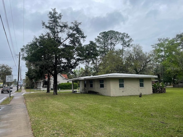 view of side of home featuring metal roof and a lawn