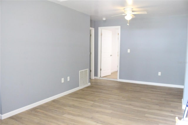 empty room with visible vents, baseboards, light wood-style floors, and a ceiling fan