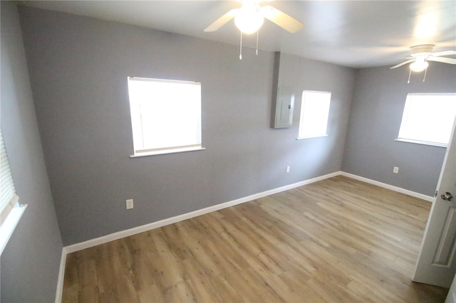 unfurnished room with ceiling fan, baseboards, and wood finished floors