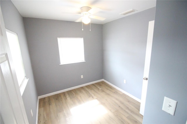 spare room featuring visible vents, baseboards, ceiling fan, and light wood finished floors