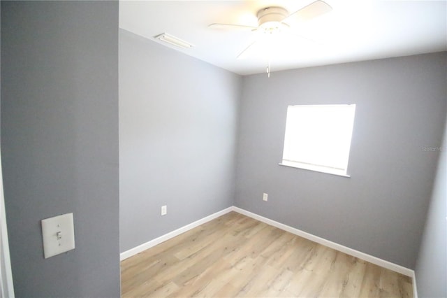 empty room featuring baseboards, a ceiling fan, visible vents, and light wood-type flooring