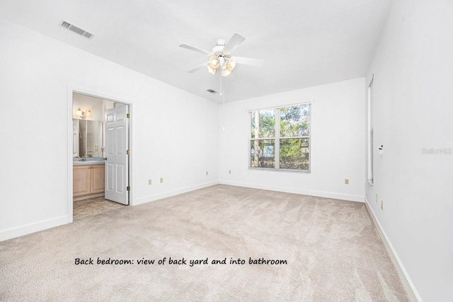 unfurnished bedroom featuring visible vents, baseboards, light colored carpet, and ensuite bathroom