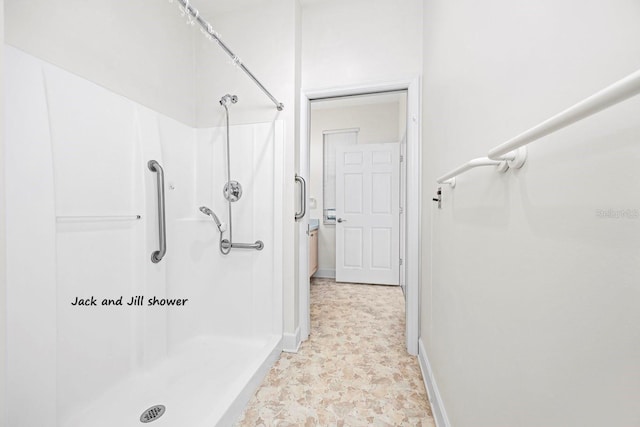 bathroom featuring baseboards and a shower stall