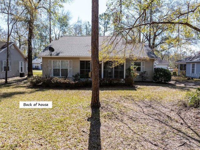 back of house with a lawn and central AC